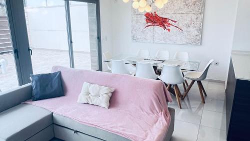 een kamer met een bank en een tafel en stoelen bij Villa with pool Marina Villamartin in Villamartin