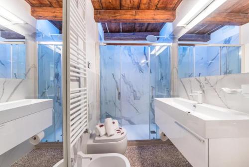 ein Badezimmer mit einem WC, einem Waschbecken und einem Spiegel in der Unterkunft Apartment Cà Brunilda-luxury penthouse with terrace in Venedig