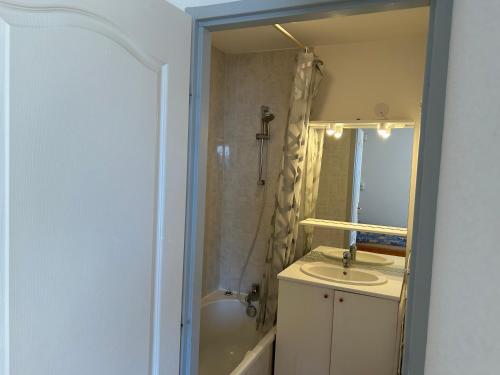 La salle de bains est pourvue d'un lavabo, d'une baignoire et d'un miroir. dans l'établissement Boost Your Immo Gardette Réallon A2, à Réallon