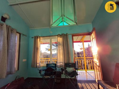 a living room with a window and a view of a balcony at BUNK CHAMBER in Mukteshwar