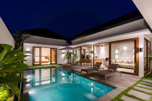 a villa with a swimming pool at night at J4 Villas Sanur in Sanur