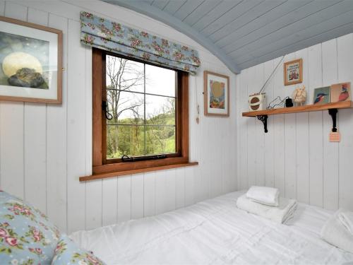 Cette petite chambre comprend un lit et une fenêtre. dans l'établissement 1 Bed in Llanidloes 56492, à Van