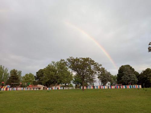 a rainbow in the sky over a field with a park at Bungalows Zaragoza Camping in Zaragoza