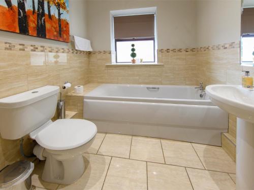 a bathroom with a tub and a toilet and a sink at 2 Bed in Harrogate HH052 in Harrogate