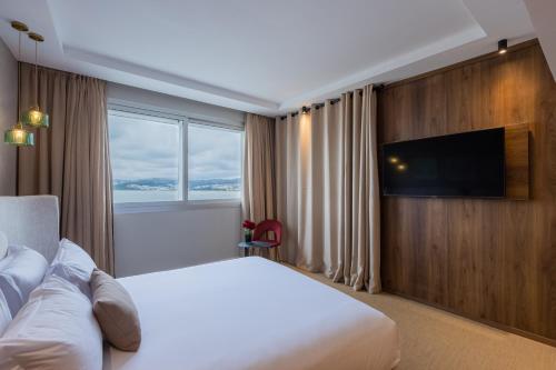 a hotel room with a bed and a flat screen tv at Kenzi Solazur in Tangier