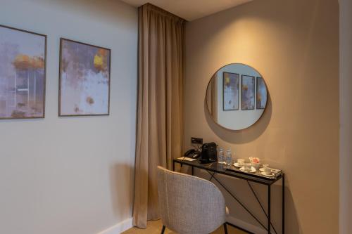 a room with a table with a mirror and a chair at Kenzi Solazur in Tangier