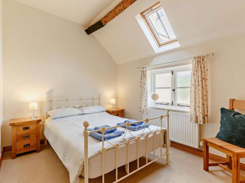 a bedroom with a white bed and a window at 3 Bed in Church Stretton 76621 in Rushbury