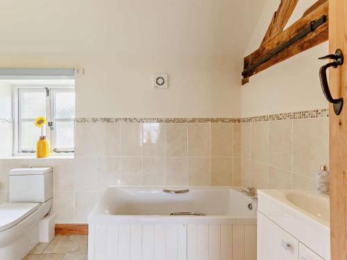 a bathroom with a white tub and a sink at 3 Bed in Church Stretton 76621 in Rushbury