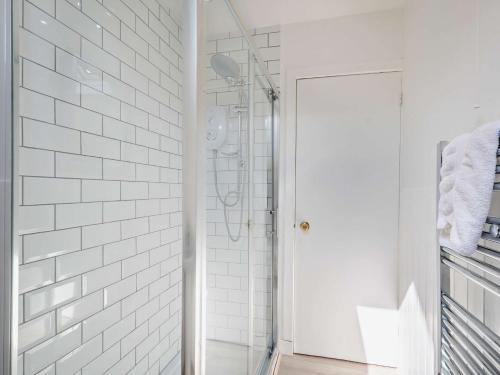 łazienka z prysznicem wyłożona białymi kafelkami metra w obiekcie 4 bed property in Whiting Bay Isle of Arran 76168 w mieście Whiting Bay