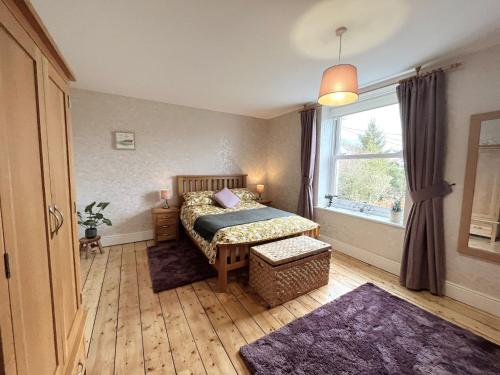 a bedroom with a bed and a large window at 3 Bed in Barnstaple 77506 in Bishops Tawton