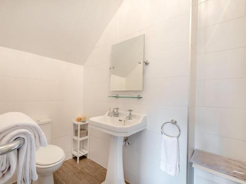 a white bathroom with a sink and a toilet at 4 bed in Loch Lomond 78669 in Stronachlachar