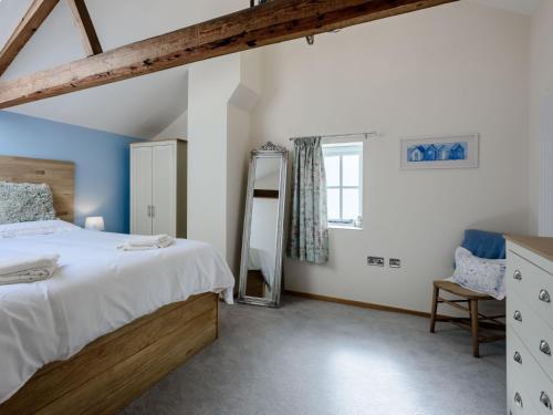 1 dormitorio con 1 cama grande y espejo en 3 Bed in Wroxham 79211, en Dilham