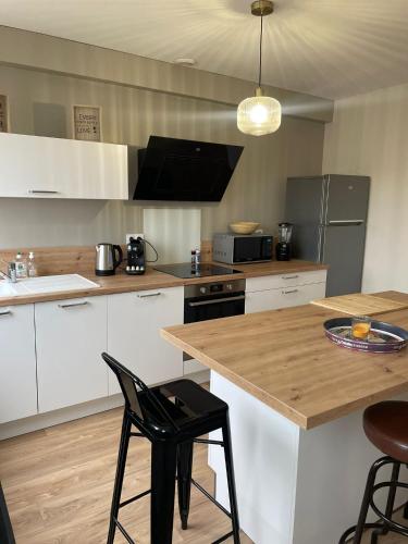 - une cuisine avec une table en bois et un comptoir dans l'établissement 2 chambres • Centre-historique, à Bourges