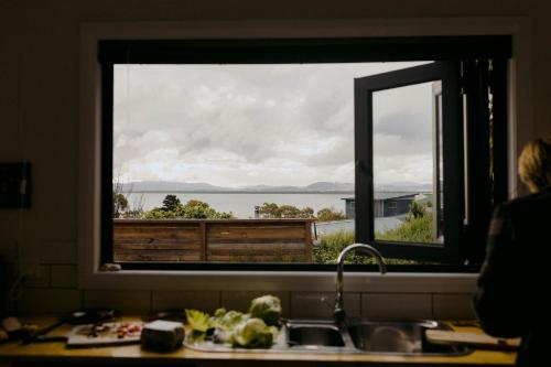 a kitchen window with a view of the water at The Sandy Sister in Dodges Ferry