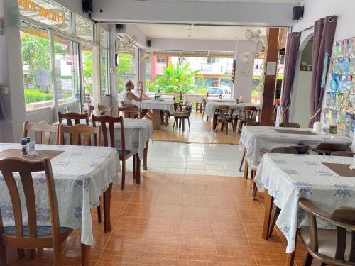 a restaurant with tables and chairs and people sitting at tables at 2 Vikings Guesthouse in Karon Beach