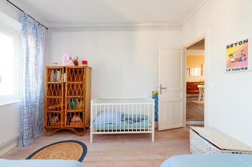 - une chambre blanche avec un lit bébé dans l'établissement La Coquille - vue mer panoramique & port Tréport, au Tréport