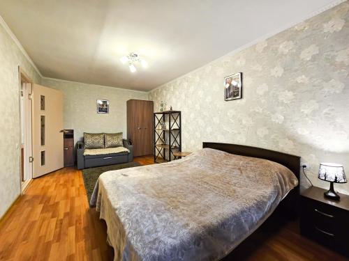 1 dormitorio con cama y sofá en Nadezhda Apartments on Gogol st. - Maulenov st., en Almaty