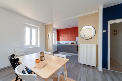 une salle à manger et une cuisine avec une table et des chaises dans l'établissement La Coquille - vue mer panoramique & port Tréport, au Tréport