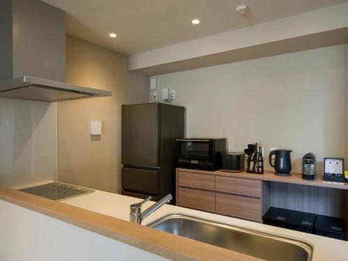 a kitchen with a sink and a stainless steel refrigerator at Rakuten STAY VILLA Nikko in Nikko