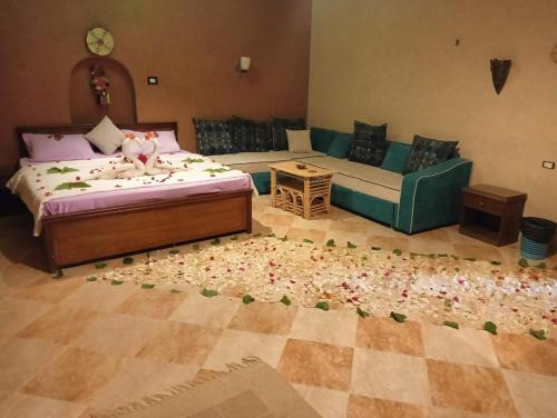 a living room with a bed and a couch at Panta Lodge Siwa بنتا لودج سيوة in Siwa