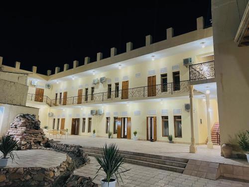 a large building with a courtyard at night at Hotel Lola in Bukhara