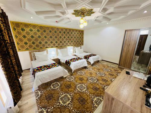 a room with three beds and a rug at Hotel Lola in Bukhara