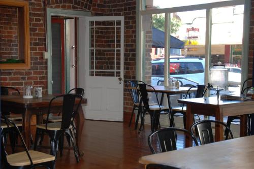 a dining room with tables and chairs and a white door at THE FED AND BED TEMORA in Temora