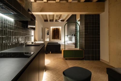 Il dispose d'une cuisine avec des murs carrelés noirs et d'une chambre. dans l'établissement Apartamentos Vilafamés Antic Palau, à Vilafamés