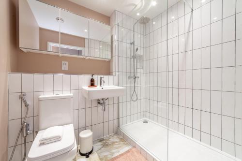 a bathroom with a toilet and a sink and a tub at Beautifully renovated 1BR Flat in Walthamstow in London