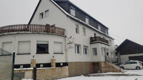 a white house with a balcony on top of it at Osteria Mediterranean in Freirachdorf