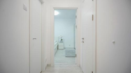a hallway with white walls and a white floor at Mountain Hideaway Apartment in Braşov