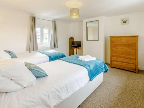 a bedroom with two beds and a dresser at 3 Bed in Bude 83223 in Marhamchurch