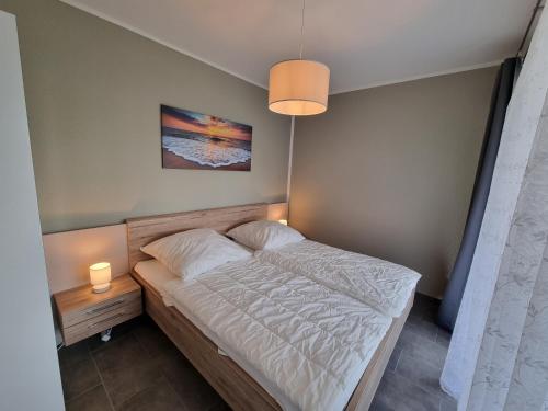 - un petit lit dans une chambre avec une lampe dans l'établissement Park-Apartment Scharmützelsee Wohnung 1, à Wendisch Rietz