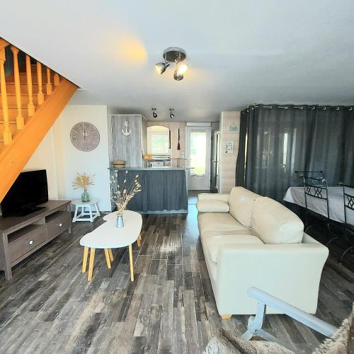 un salon avec un canapé et une table dans l'établissement A seulement 150m plage et commerces maison 90m2 4 pièces avec parking privé et 2 terrasses sud, à Saint-Jean-de-Monts
