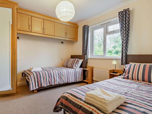 1 dormitorio con 2 camas y ventana en 2 Bed in Bude 87225, en Kilkhampton