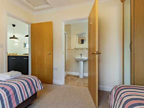 1 dormitorio con 1 cama y baño con lavamanos en 2 Bed in Bude 87225, en Kilkhampton