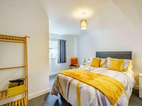 a bedroom with a bed and a yellow blanket at 2 Bed in Cockermouth 85514 in Cockermouth