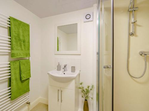 a white bathroom with a sink and a shower at 2 Bed in Cockermouth 85514 in Cockermouth