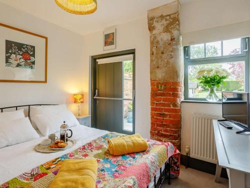 een slaapkamer met een bed met een tafel en een raam bij 1 bed property in York 87323 in Green Hammerton