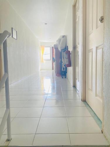a hallway with a white tiled floor in a house at 2 Vikings Guesthouse in Karon Beach