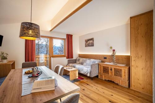 a living room with a table and a couch at App Hubertus - Wasserfallspitz in Sand in Taufers