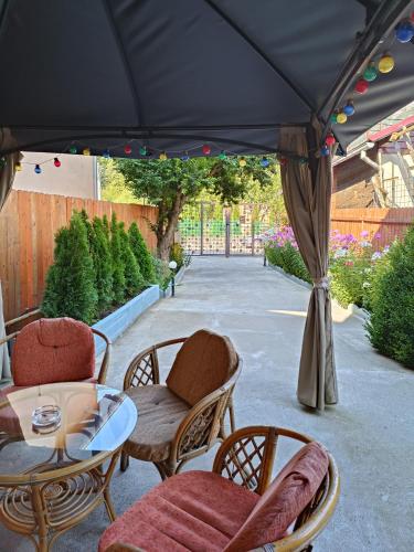 a patio with a table and chairs under a black umbrella at D&D Busteni in Buşteni