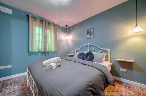 a bedroom with a large bed with blue walls at Boho Rooms Sliema in Sliema