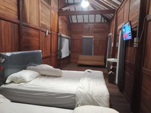 a bedroom with a bed and a tv in it at NK Villa Syariah And Cafe Prigen in Pasuruan