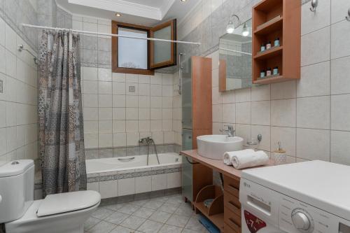 y baño con aseo, lavabo y bañera. en Idalia Nature Haven, Three-Bedroom Apartment, en Kournás