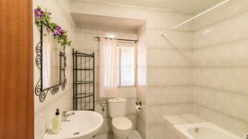 une salle de bain blanche avec toilettes et lavabo dans l'établissement Casa de Paquita Montefrio by Ruralidays, à Montefrío