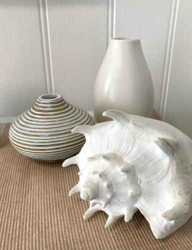 a table with a white vase and a white vase at Bridairre in Bridport