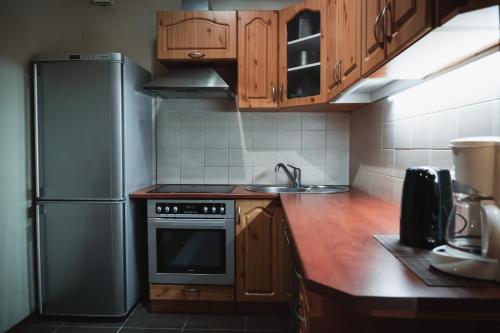 a kitchen with wooden cabinets and a stainless steel refrigerator at Viljandi Jahiloss in Viljandi