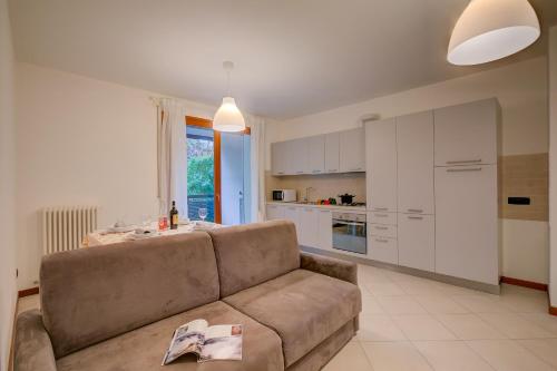 a living room with a couch and a kitchen at Magnolia - Happy Rentals in Laveno-Mombello