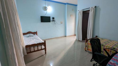 um quarto com uma cama e uma televisão na parede em Delight Homestays Coorg em Kushalanagar